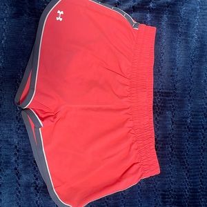 Bright pink Under Armour athletic shorts.